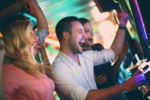 A group of friends enjoying their time playing slots. They've called Refund Management Services to ensure they recover their 30% withholding tax.