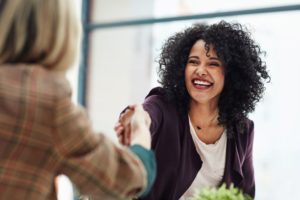 A satisfied customer shakes hands with her rep at Refund Management Services.