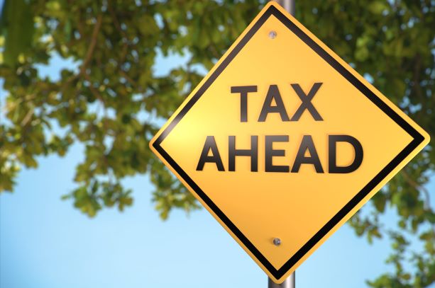 Road sign that says "Tax Ahead" as a warning to Canadians who gamble in the United States. Refund Management Services can help recover tax withholdings.