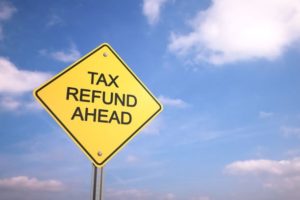 Road sign reading "Tax Refund Ahead" on an azure sky. Refund Management Services can help you recover your tax withholding.